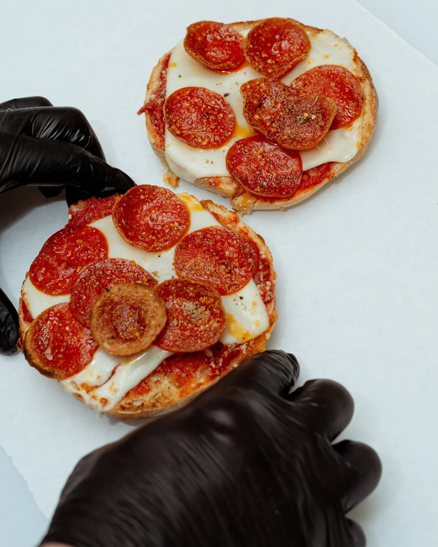 Making pizza bagels with sauce and cheese