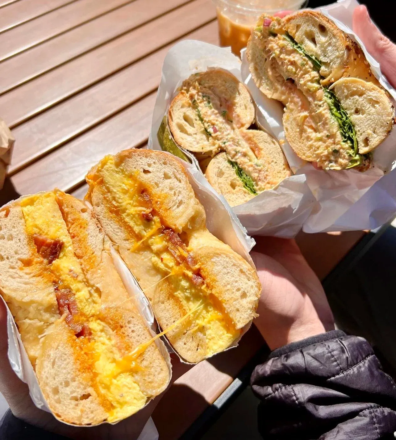 Friends sharing bagel sandwiches together