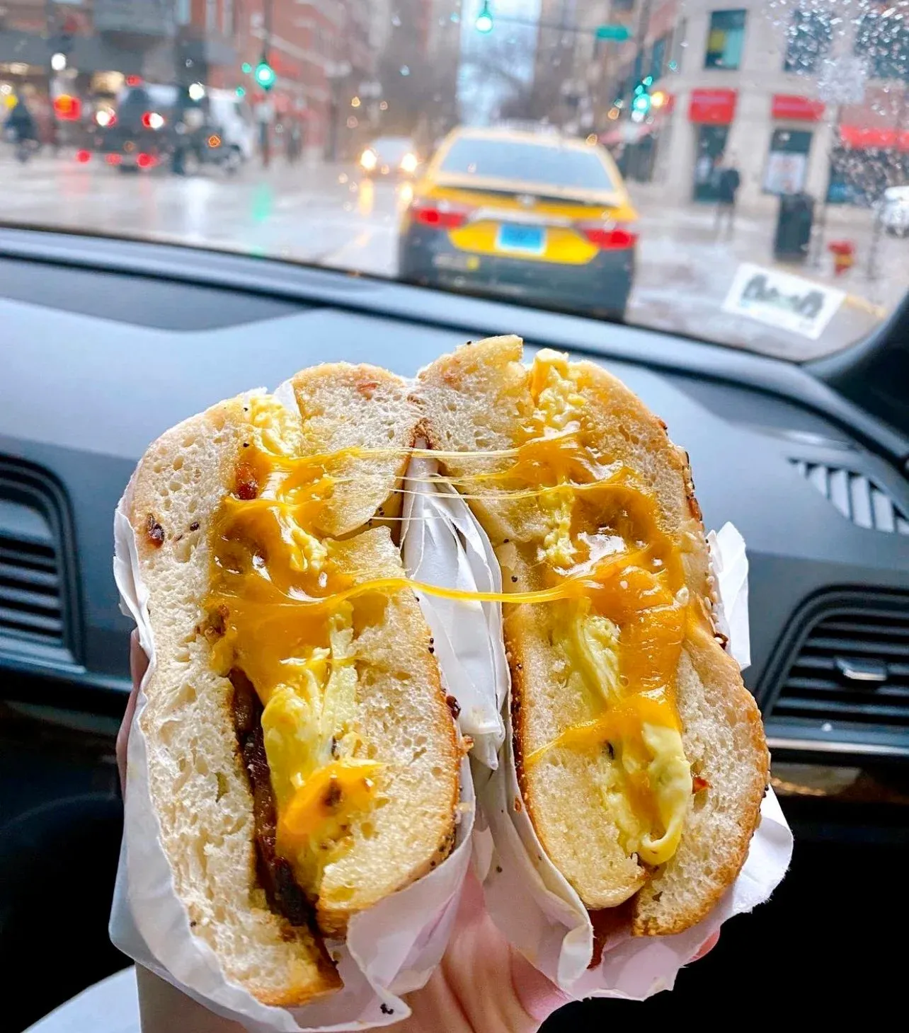 Bacon egg and cheese bagel with melted cheese pull