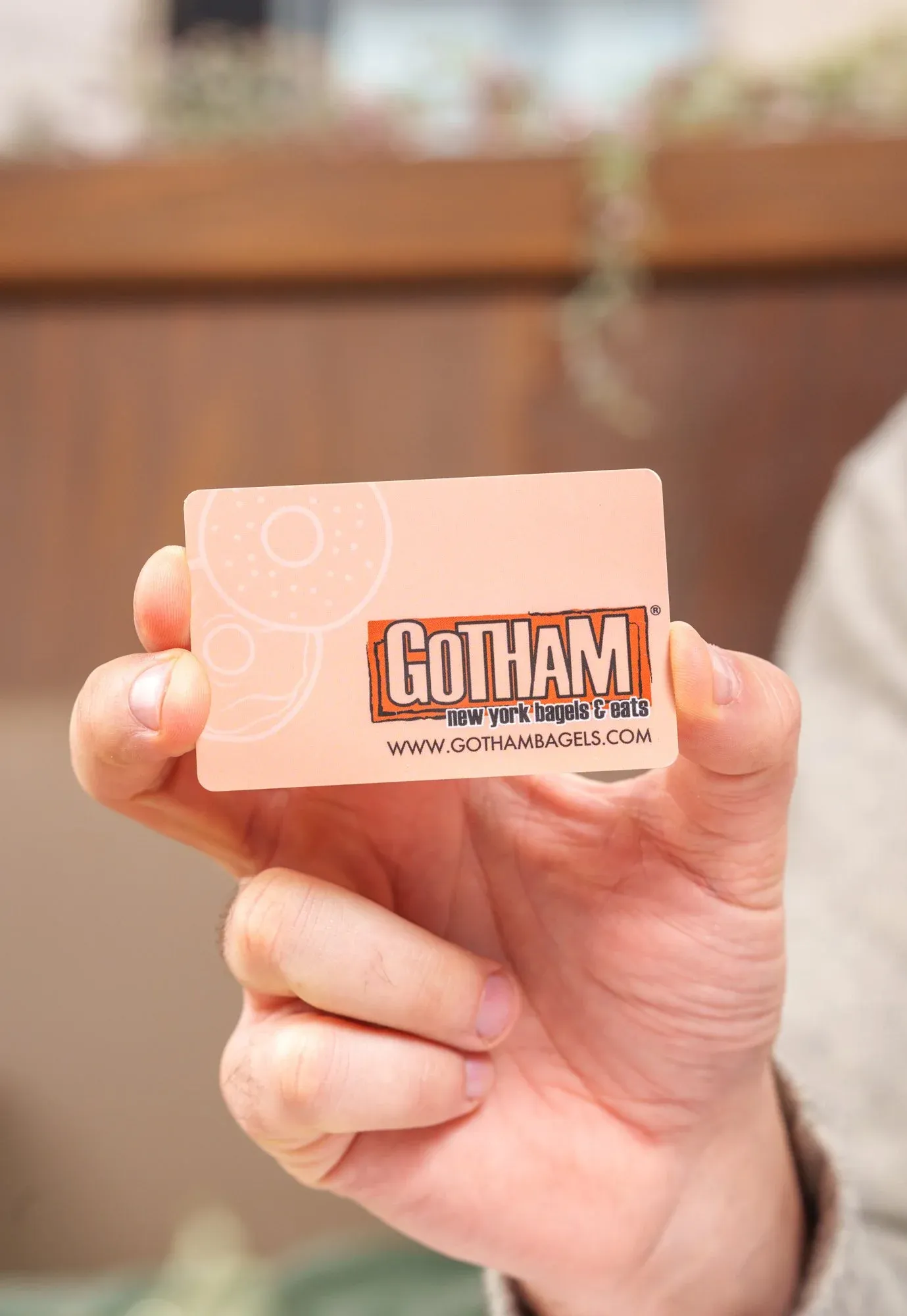 A Gotham Bagels gift card resting on a stack of fresh bagels