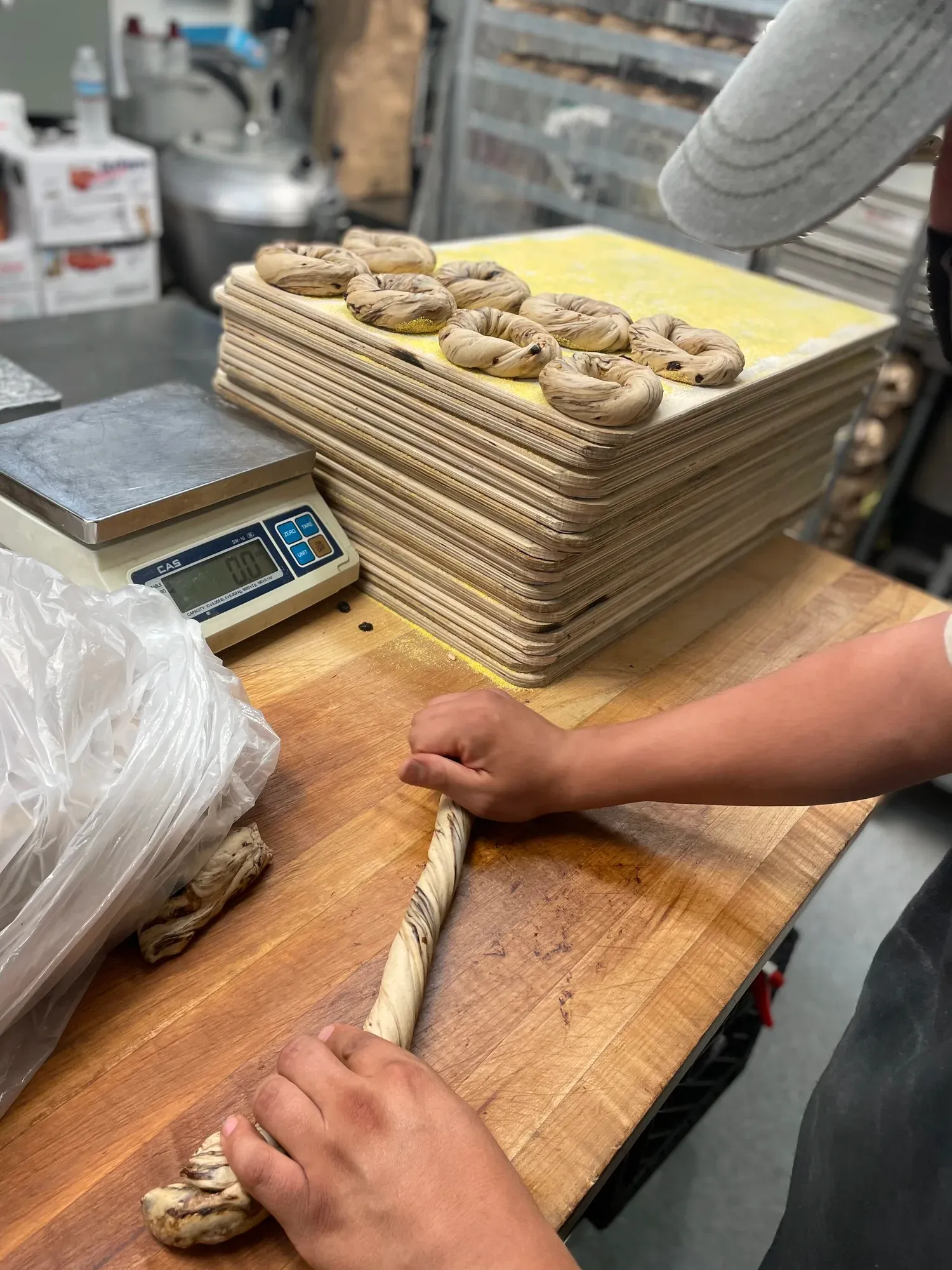 Baker hand-rolling bagels at Gotham Bagels
