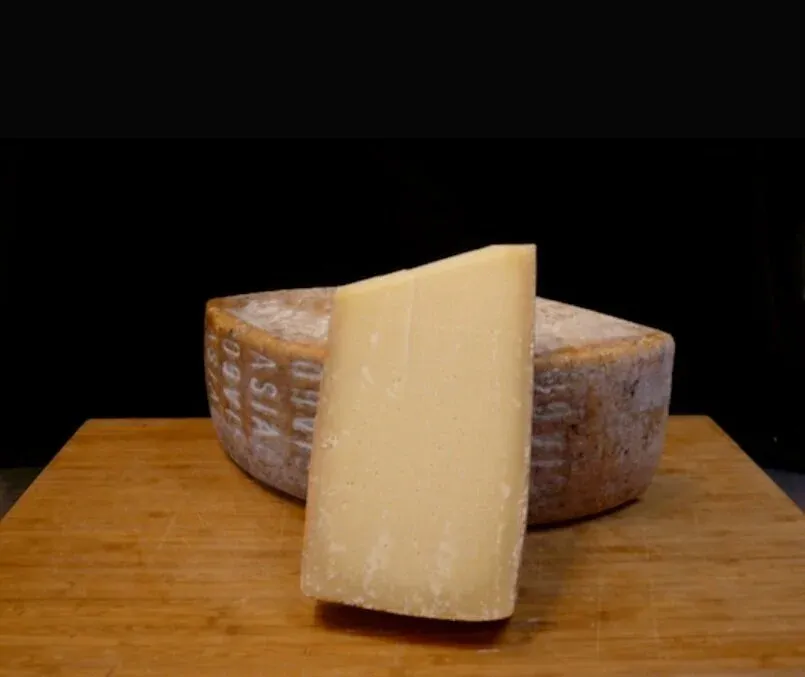 Asiago cheese cut from the wheel